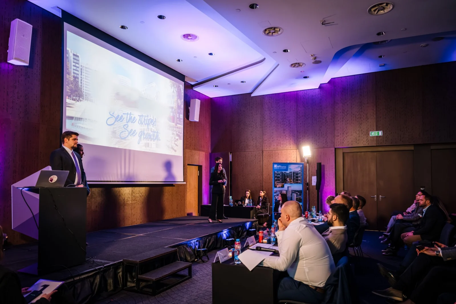 Students presenting their case solution on stage to the BBICC panel of judges